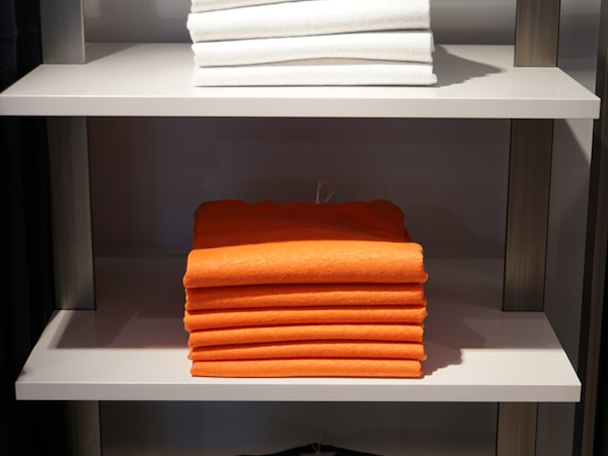 Folded orange and white garments arranged as finalized order items